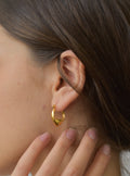 a close up of a person wearing a pair of earrings