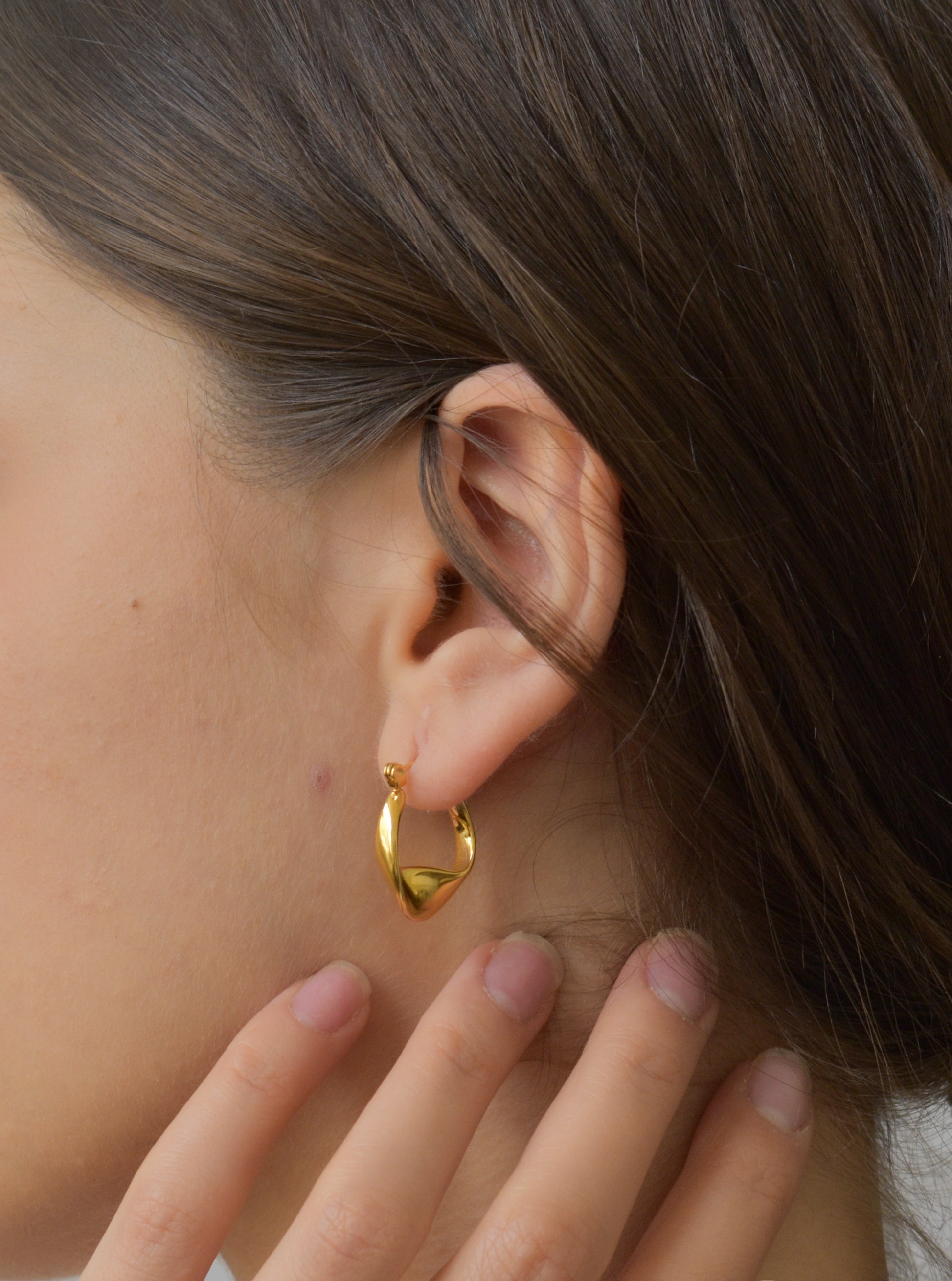a close up of a person wearing a pair of earrings