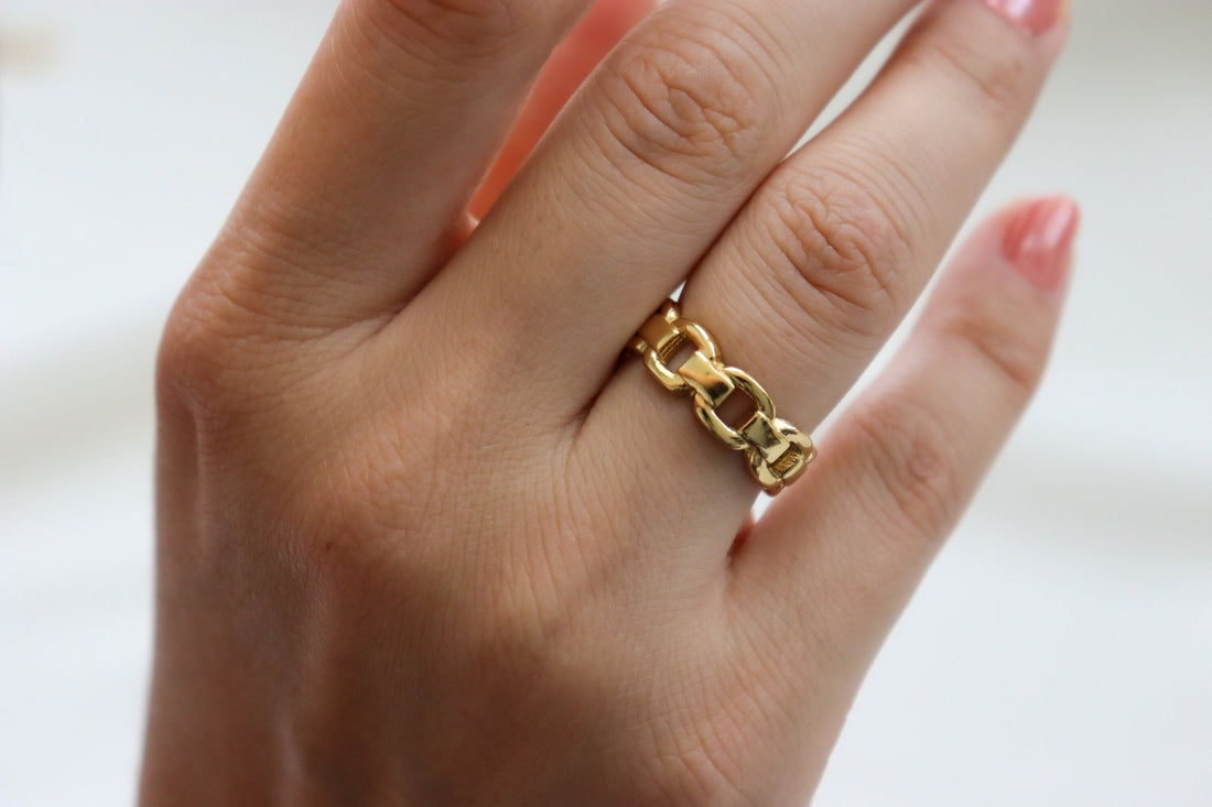 a gold ring with a chain on it